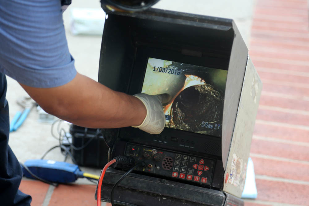 technician watching footage from sewer camera inspection