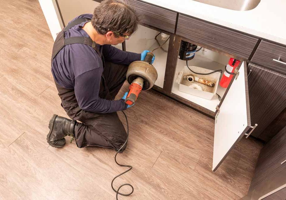 technician snaking a drain