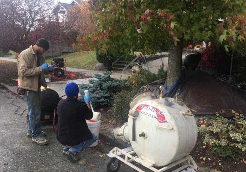 technicians repairing damaged underground sewer line